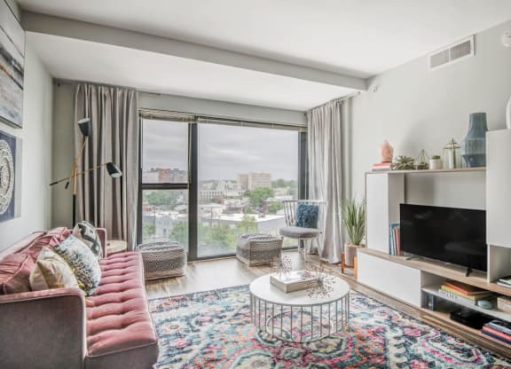 a living room with a couch and a tv and a window