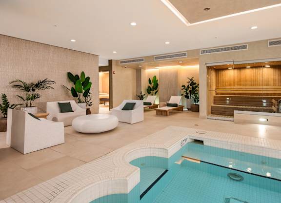 Calm spa lounge with natural materials, soft lighting, and a neutral color palette.