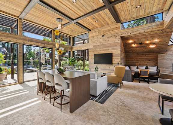 A modern kitchen and dining area with wooden ceiling and furniture.
