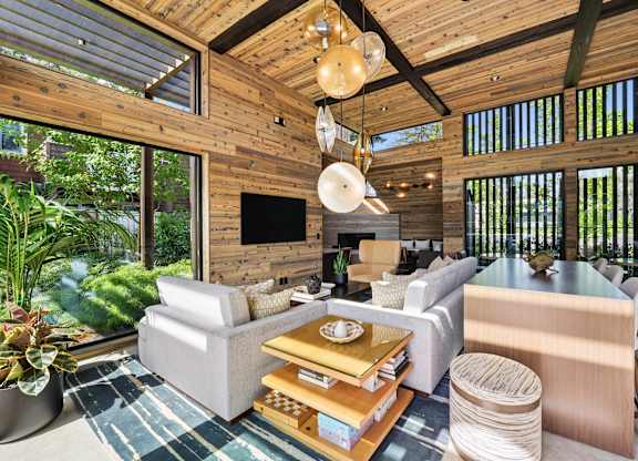 A living room with a wooden ceiling and a flat screen TV.