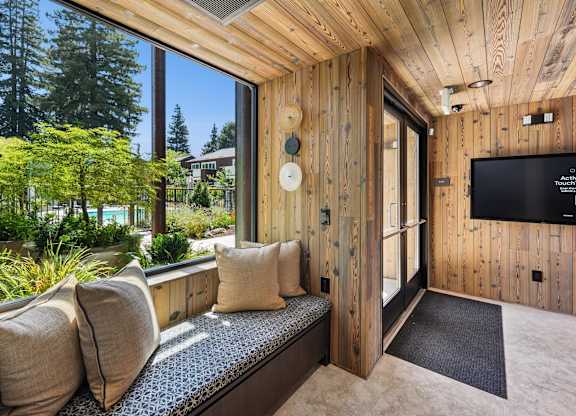 A room with a wooden wall and a window seat.