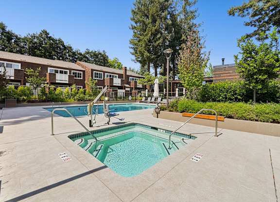 A swimming pool surrounded by a concrete floor and a metal railing.