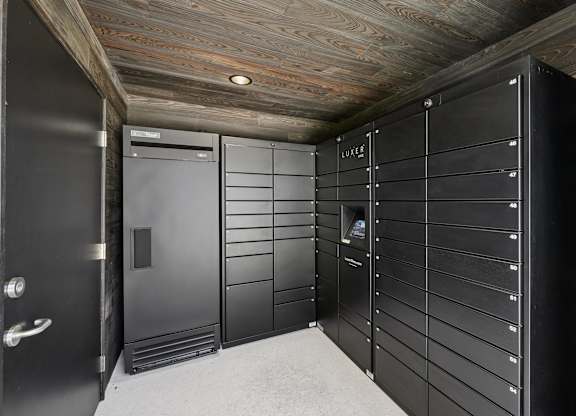 A row of black lockers in a room with wooden ceiling.