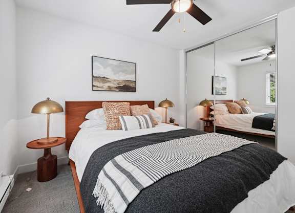 A bedroom with a large bed and a ceiling fan.