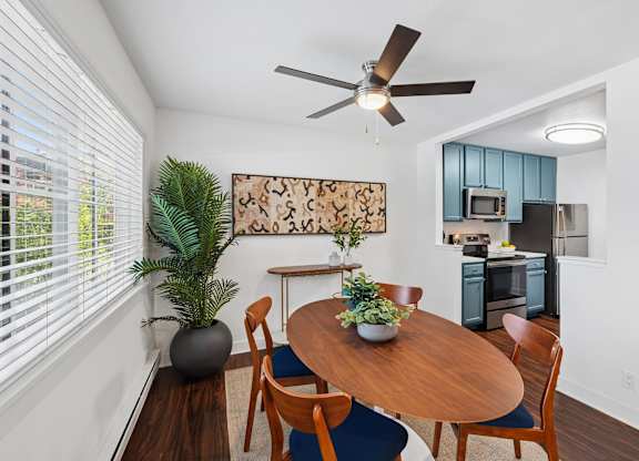 A dining room with a wooden table and chairs.