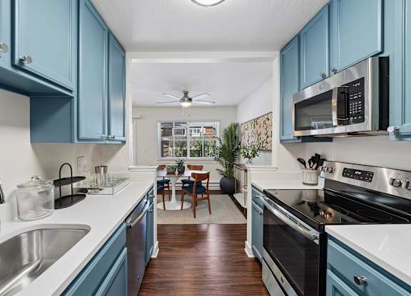 A kitchen with blue cabinets and a white counter.