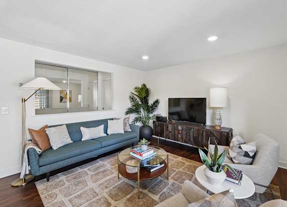 A living room with a couch, a coffee table, and a television.