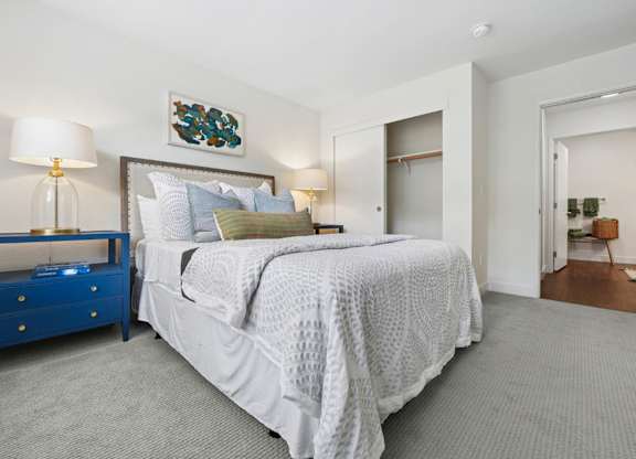 Bright bedroom at Pescadero Apartments with soft finishes, plush carpeting, and spacious closet storage.