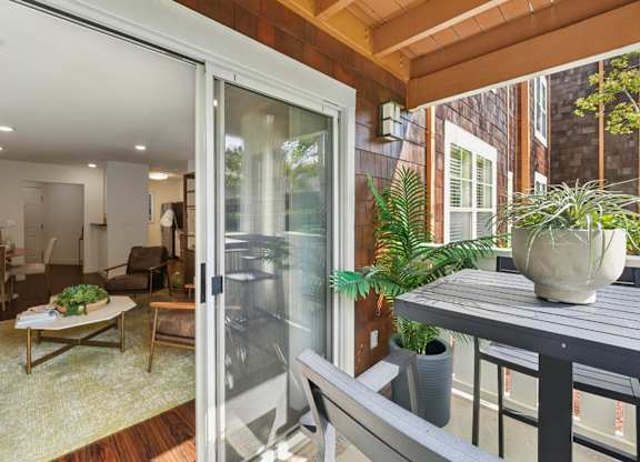 Private patio and living room at Pescadero Apartments with outdoor seating and bright interior design.
