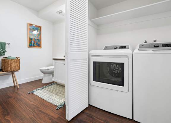 In-home washer and dryer at Pescadero Apartments with spacious utility and bathroom area.