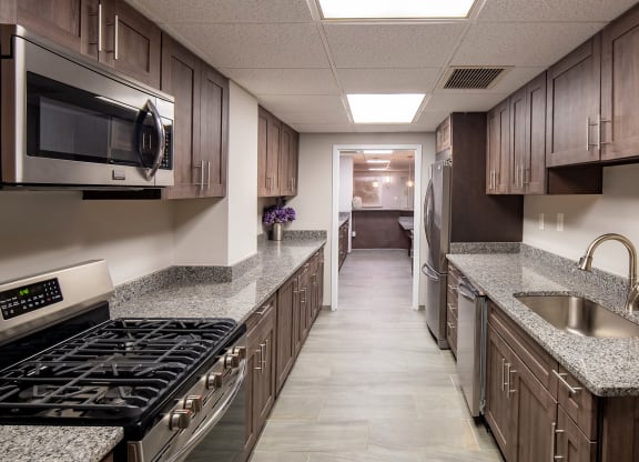 a kitchen with granite counter tops and wooden cabinets
