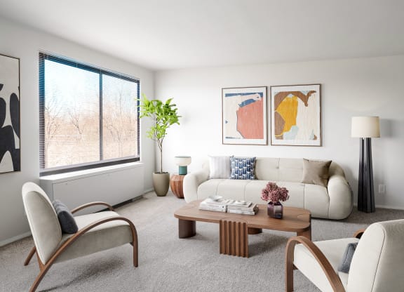a living room with white furniture and a large window
