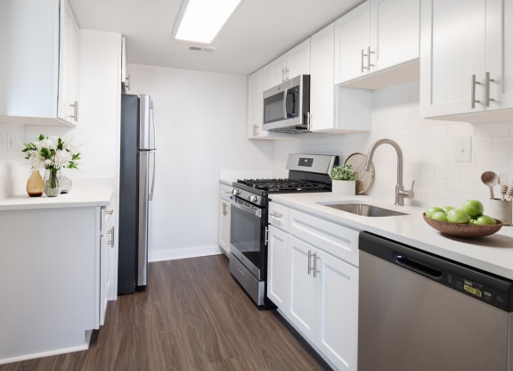 a kitchen with white cabinetry and stainless steel appliances