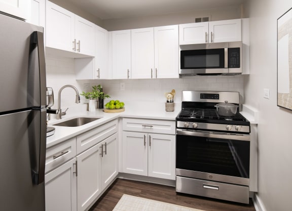a kitchen with stainless steel appliances and white cabinets