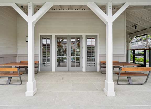 Covered outdoor seating area with table and pool views