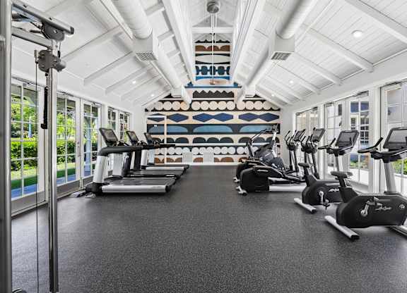 Fitness center with treadmills, stationary bikes, and strength equipment at The Presidio Apartments