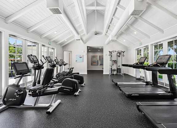 Spacious fitness center with cardio machines and high ceilings