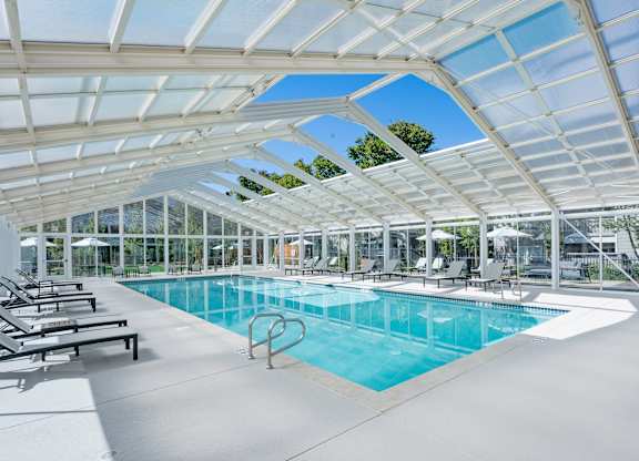 Indoor pool with lounge chairs and glass enclosure