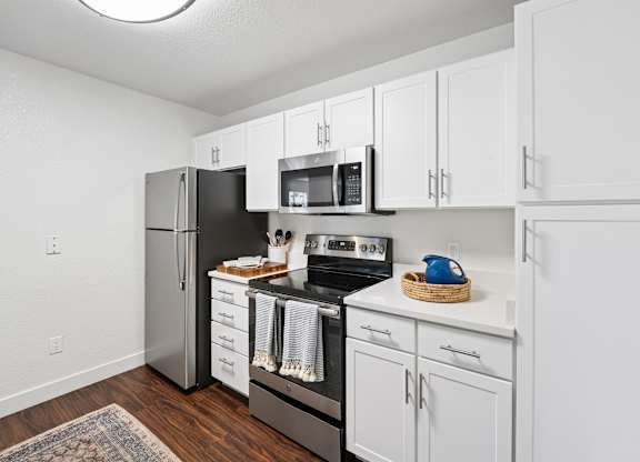 A kitchen with white cabinets and appliances.