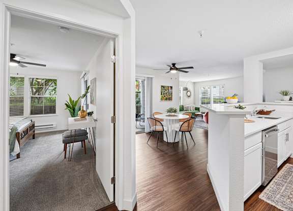 A white kitchen with a table and chairs in the middle of the room.