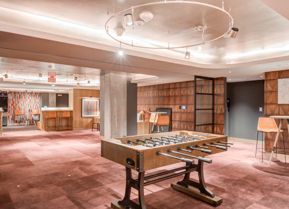 a large room with a foosball table and a bar