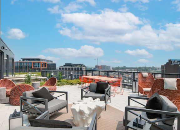 a roof top patio with furniture and a view of the city