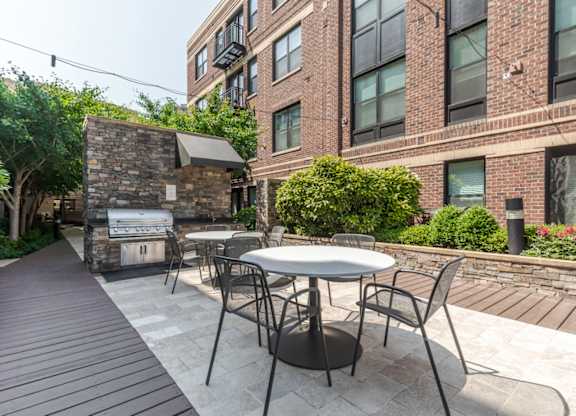 Image showing Outdoor grill station with stainless steel grills and modern seating area.