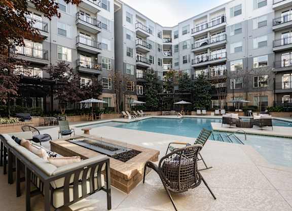 A large outdoor pool area with a table and chairs.
