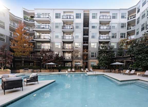 A large swimming pool in front of apartment buildings.