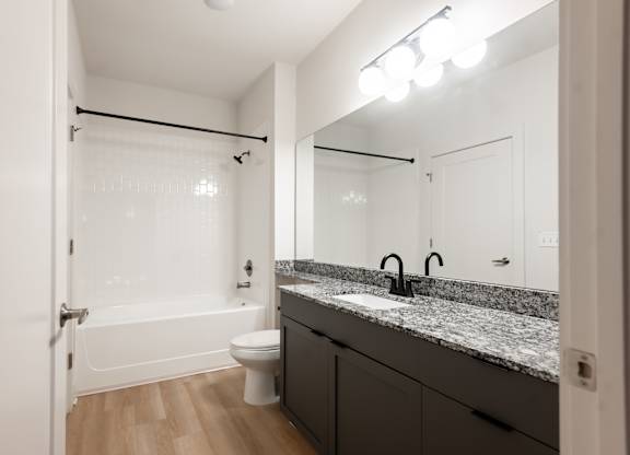 A bathroom with a sink, mirror, and toilet.