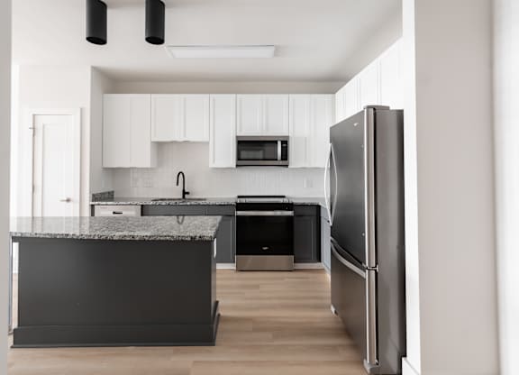 A modern kitchen with a refrigerator on the right.