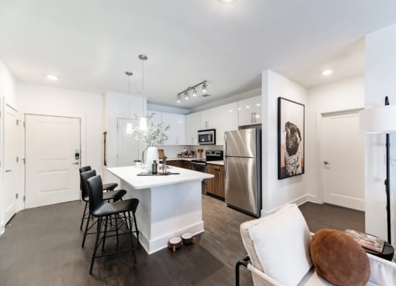 a kitchen with a white counter top and a stainless steel refrigerator