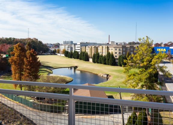 a view of a golf course and a pond from a balcony