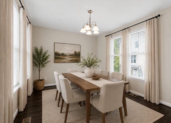 Dining room with large windows, overhead light fixture, and neutral finishes.