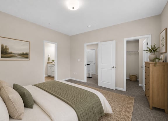 Spacious townhome bedroom with neutral walls, attached bathroom, and walk-in closet access.
