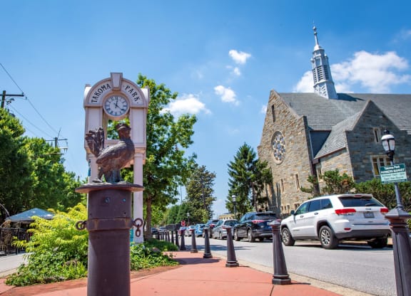 a bird statue on the sidewalk in front of a church