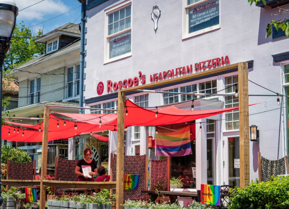 a restaurant with red umbrellas in front of a white building