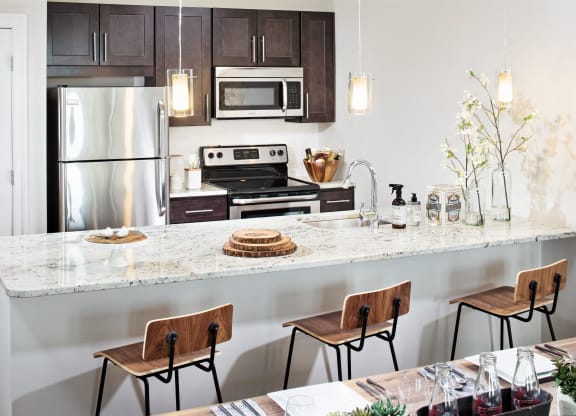 a kitchen with a marble counter top and stainless steel appliances