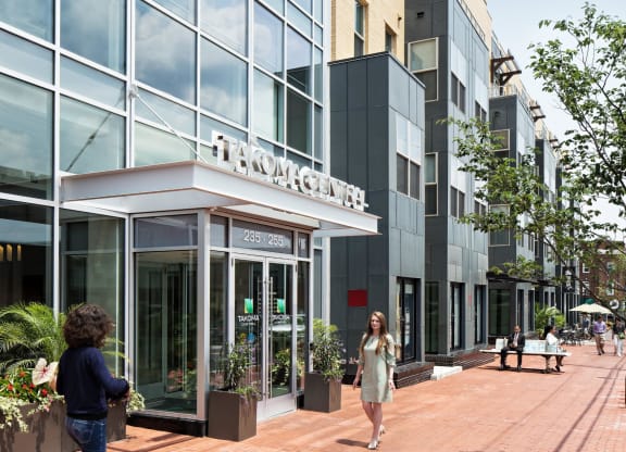 people walking in front of a building on a sidewalk