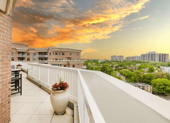 a balcony with a view of the city at sunset