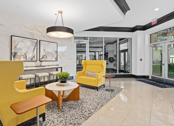 a lobby with yellow chairs and a table