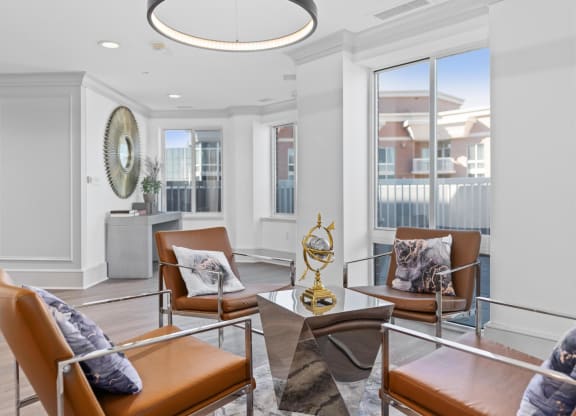 a living room with leather chairs and a chandelier