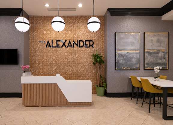 A reception area with a brown patterned wall and a white reception desk.