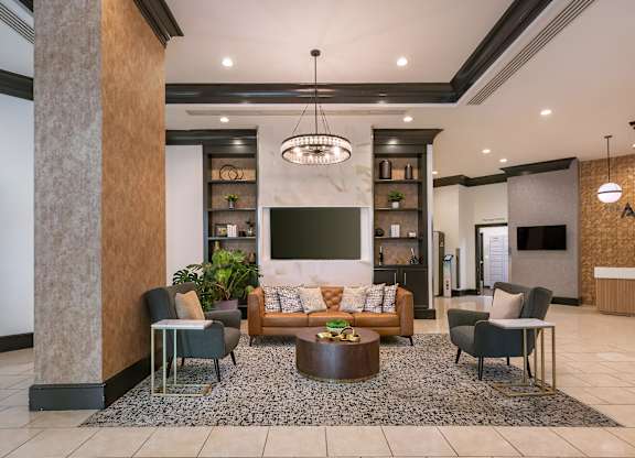 A modern living room with a large sofa, a coffee table, and a TV.