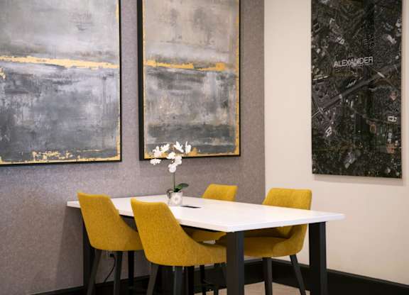 A dining room with a white table and yellow chairs.