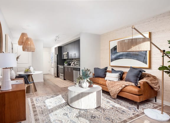 a living room with a brown leather couch and a white table