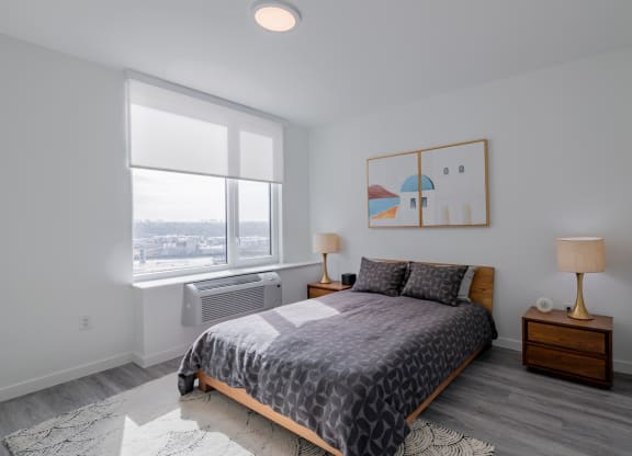 a bedroom with a bed and a large window