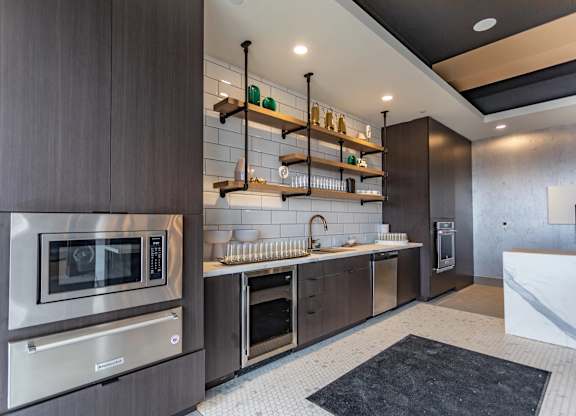 A modern kitchen with dark wood cabinets and stainless steel appliances.
