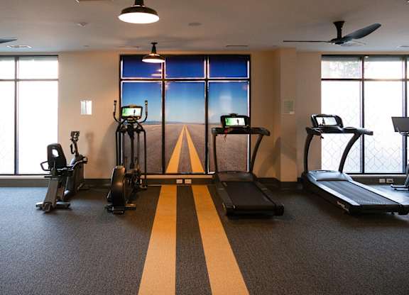 A gym with treadmills, elliptical machines, and other exercise equipment.