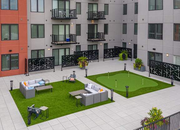 A modern apartment complex with a courtyard and seating area.